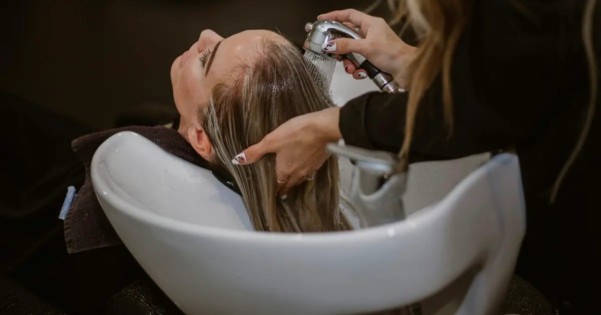 A woman getting her hair cut by a hair stylist